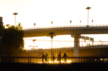 Gente cruzando puente peatonal al atardecer 