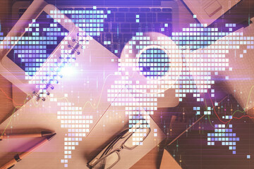 Double exposure of business theme hologram over desktop with phone. Top view. Mobile international...