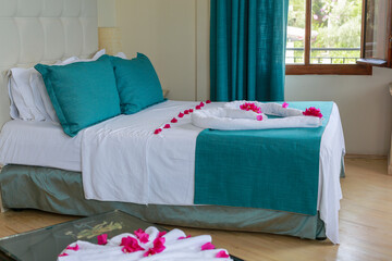 A hotel bed decorated with roses