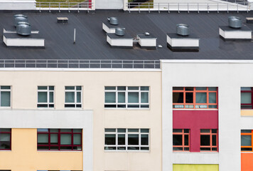 Residential apartment building exterior with ventilation system on the black flat top roof
