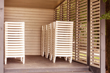 Stack of white sun beds wooden gazebo or canopy