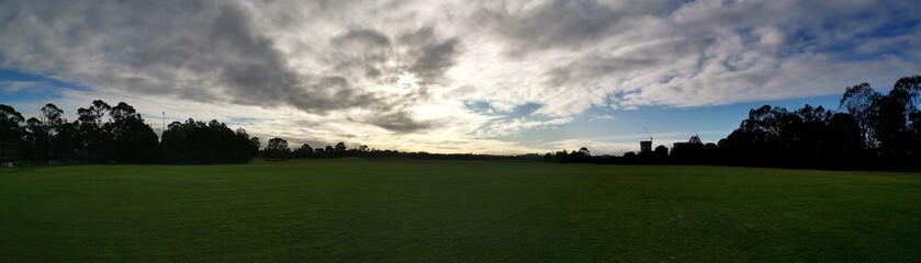 Beautiful morning panoramic view of a park with green grass and trees in the background, Ermington, New South Wales, Australia