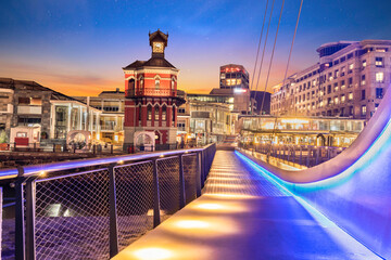 Waterfront clock tower and swinging bridge at night in Cape Town South Africa