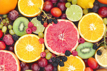 Fototapeta na wymiar Crate of fresh ripe sweet fruit harvest: apple, orange, grapefruit, qiwi, banana, lime, blackberry, raspberry, plum, grape
