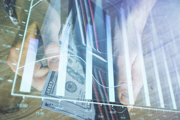 Multi exposure of forex graph drawing hologram and USA dollars bills and man hands. Technical Analysis concept.