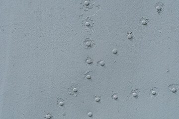 Closeup of metal with rows of rivets.
