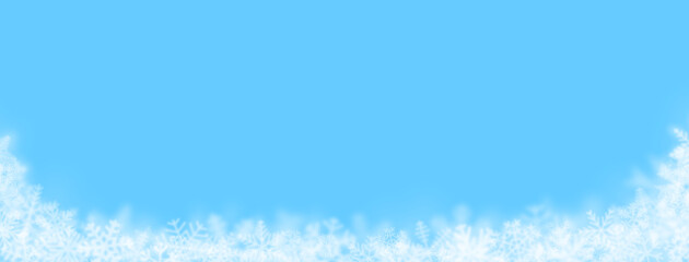 Christmas background of snowflakes of different shapes, sizes, blur and transparency on light blue background