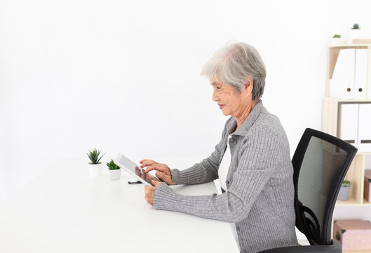 old asian woman learning to use tablet computer, she search information with internet technology, brain training with education online, elderly learning  activity
