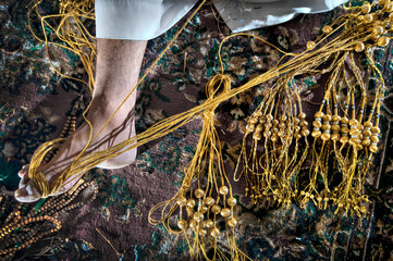 Handcraft of an Arab man using golden threads to make Arab bisht