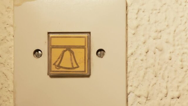 Male hand pressing  doorbell switch.