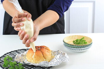 Baking Process Add Cream Cheese to Korean Garlic Cream Cheese Bread (Yugjjog Maneulppang) is Popular Street Food in Korea. Made from Bread Bun, Cream Cheese, Garlic, Parsley, and Honey