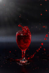 Red wine in a glass on a black background shining on the ground Show happy celebration