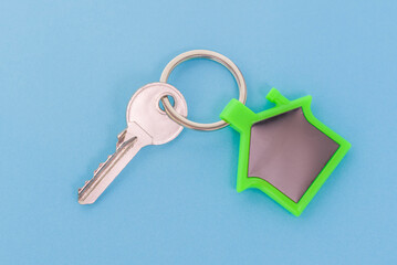 key chain with house symbol and keys on blue background,Real estate concept