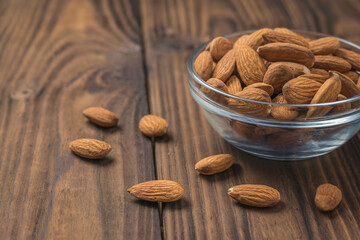 Large almonds in a glass Cup on a wooden table.