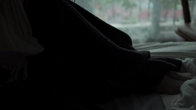 Silhouette of Depressed Young beautiful Asian woman sitting alone on bed in apartment with crying and screaming. Loneliness sad girl think of grief trouble. Negative emotion and mental health concept.