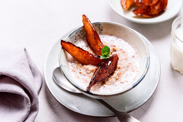 Milk Buckwheat Porridge with Caramelized Pears on grey concrete background. Healthy breakfast. Selective focus