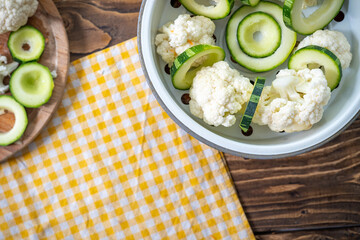 Fresh vegetables zucchini and cauliflower are sliced on a cutting Board.