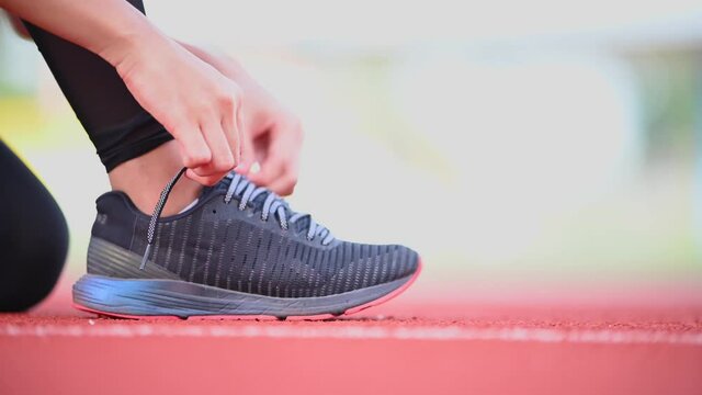 An Asian woman sat on a cable tie on a treadmill on a running track.