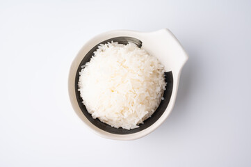 Bowl of boiled rice served on wooden table,