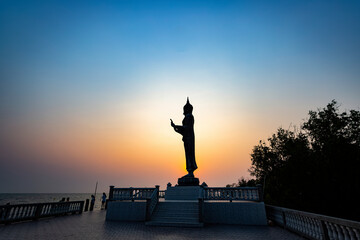 The Statue of Buddha on sunset sky background.