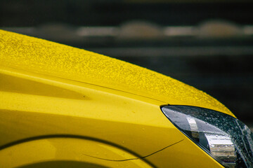 View of a traditional yellow Hungarian taxi for passengers driving under the rain through the...