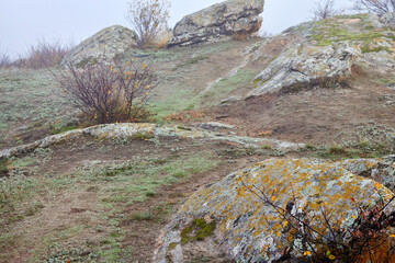 Fototapeta premium Pile of huge stones of rocks in the autumn fog at sunrise
