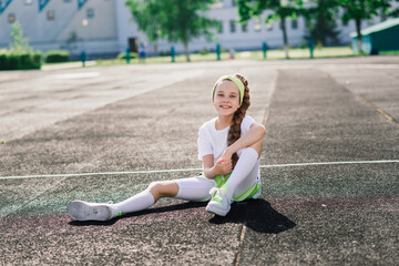 Girl jogging on a sunny summer evening, laying on treadmill, stadium, physical training, back to school.