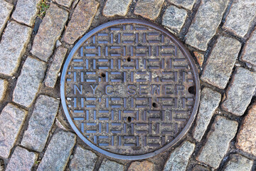 Manhole cover and old street in New York