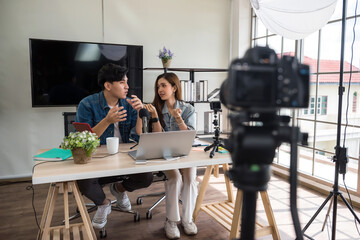 2 young Asian vlogger using video online live streaming and broadcasting. Happy couple of bloggers recording a video to live in social networks.