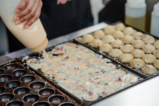 Woman Pouring Batter Into Pan With Ball-shaped Molds