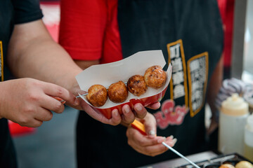 Vendor putting Takoyaki balls into paper box