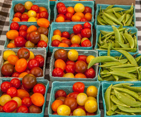 Heirloom cherry tomatoes and green peas at a farmers market