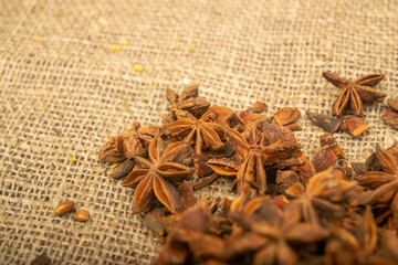 A pile of star anise on a background of burlap with a rough texture surface texture. Close up.