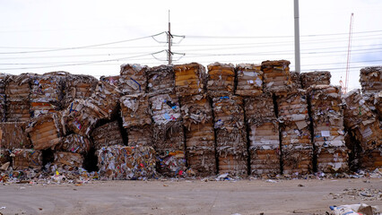 Bales of cardboard and box board. Wastepaper for Recycling. Background of paper textures piled ready to recycle on yard © Socoxbreed