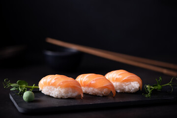 fresh salmon sushi on black board