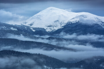 Misty mountain top covered with fresh snow