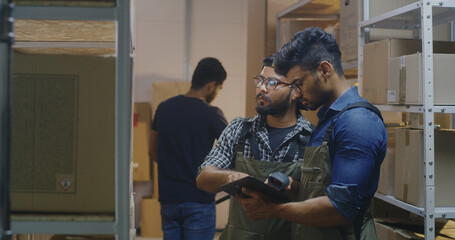 Obraz premium Workers checking boxes in a distribution center