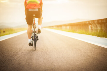 Bike at the summer sunset on the road. Cycle closeup wheel on blurred summer background.