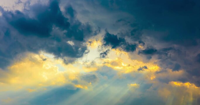 Rolling dark clouds and sunlight beams in the sky.sky and clouds with the sun.4K Time lapse.