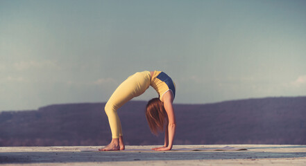 Young gymnast girl perform various gymnastic and yoga exercises, including splits and bending over...
