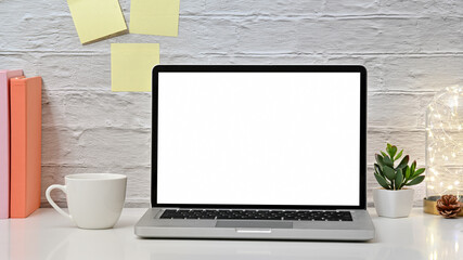 Cropped shot view of mock up modern home office desktop laptop with coffee cup, book and blank...