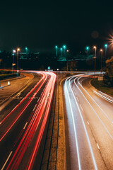 Fototapeta na wymiar light trails of cars at night approaching a roundabout