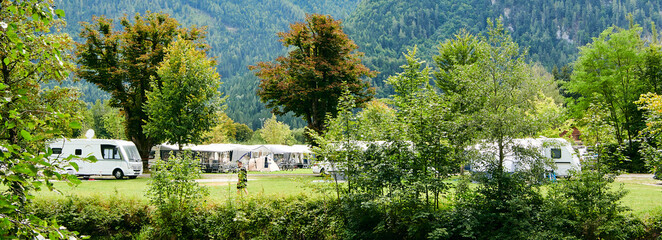 Fototapeta na wymiar Schönes Camping mit Wohnwagen im Sommer am Fluss in Bergen Naturcamping 