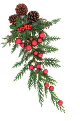 Christmas decoration with holly, cedar cypress, pine cones & red baubles on white background. Decorative xmas element for the festive season. Flat lay.