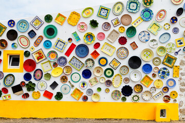 ALGARVE, PORTUGAL - APRIL 28, 2017: Vintage clay plates, pots and bowls used as a wall decoration motif. Portugal