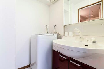 Washbasin and washing machine set in front of the bathroom
