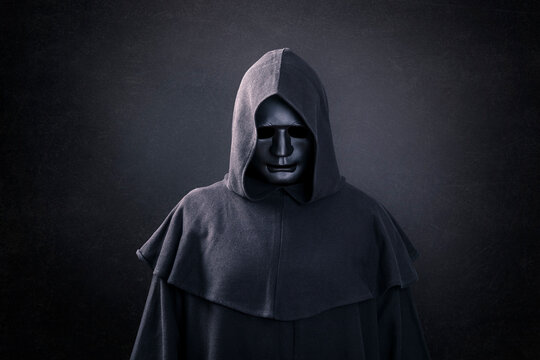 Scary Figure With Mask In Hooded Cloak In The Dark