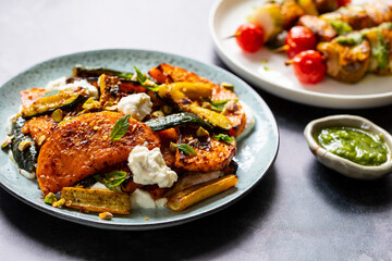 Roast butternut squash and courgettes with feta and yougurt sauce and salmon skewers