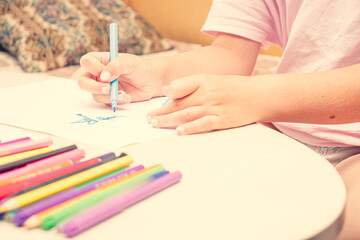 Favorite activity of the child. A happy family. The girl draws with colored markers. Girl's hands.
