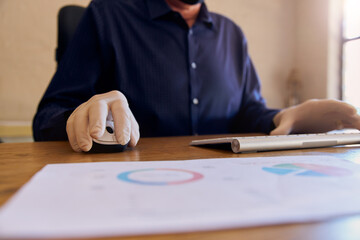 Anonymous Businessman working at desk wearing protective gloves